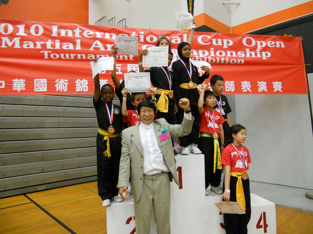 El Gran Maestro Chiu Chi Ling levantando su puño como símbolo de triufo junto a estos pequeños campeones.